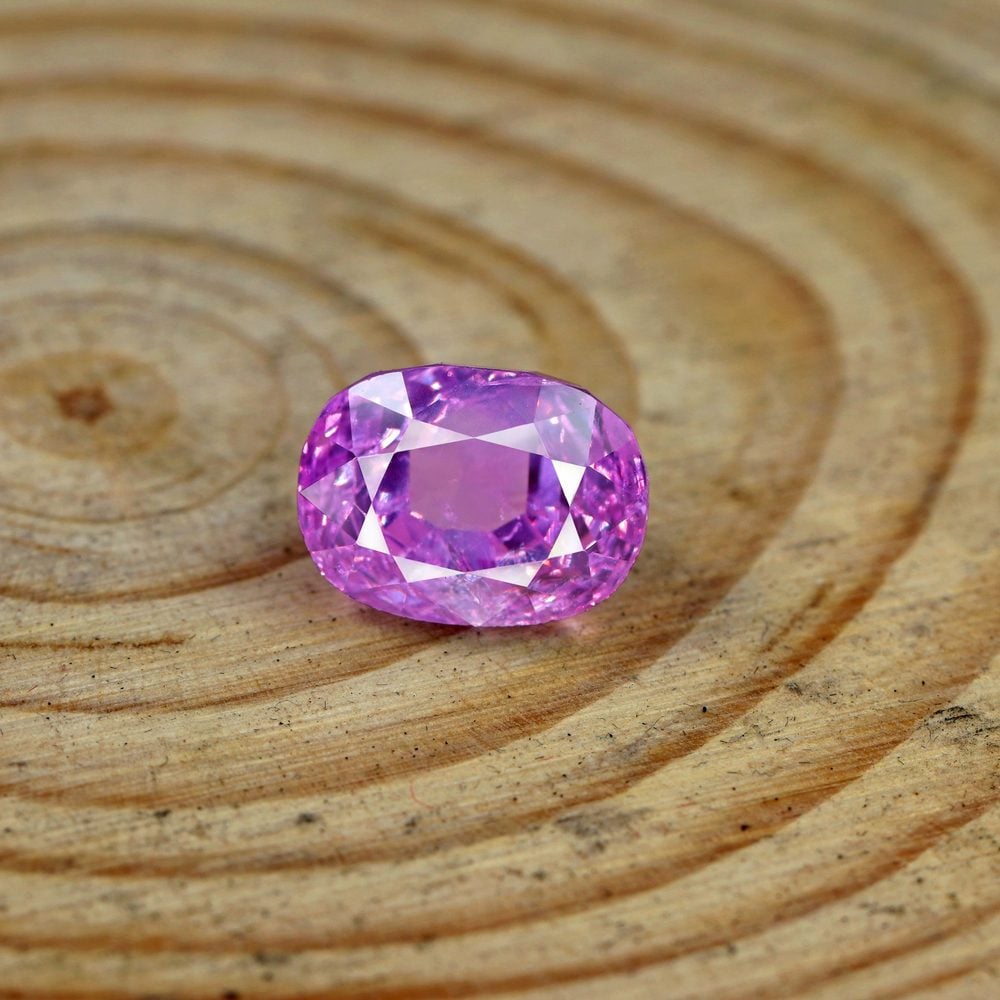 Tourmaline rose taillée posée sur un plan en bois