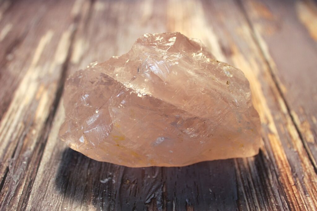 Bloc de quartz rose sur une table en bois
